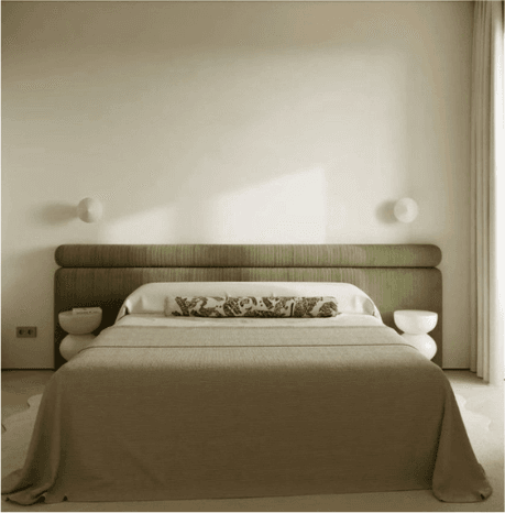 The same bedroom with an empty wall above the bed
